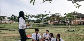 Limitless vs Limited Students in uniforms enjoying an outdoor class with a teacher in a park setting.